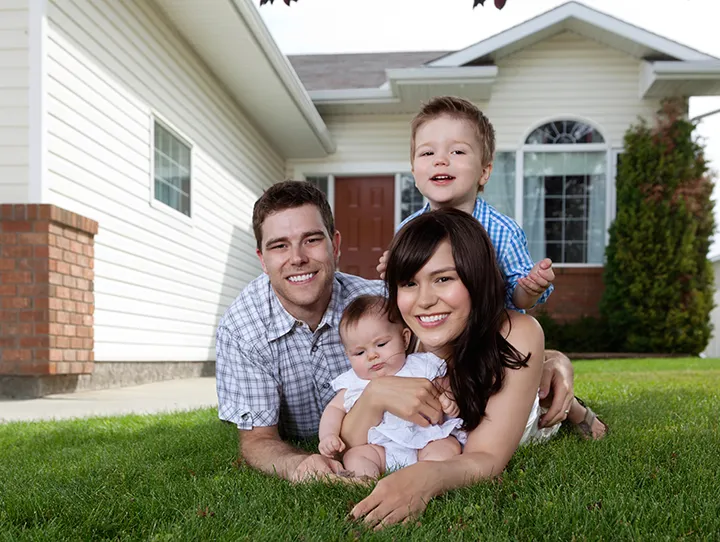 A family outside their home that is covered by an auto home insurance bundle in Elkhart